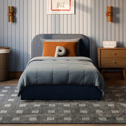 Bedroom with a bed, nightstand, and decorative elements on a striped wall.